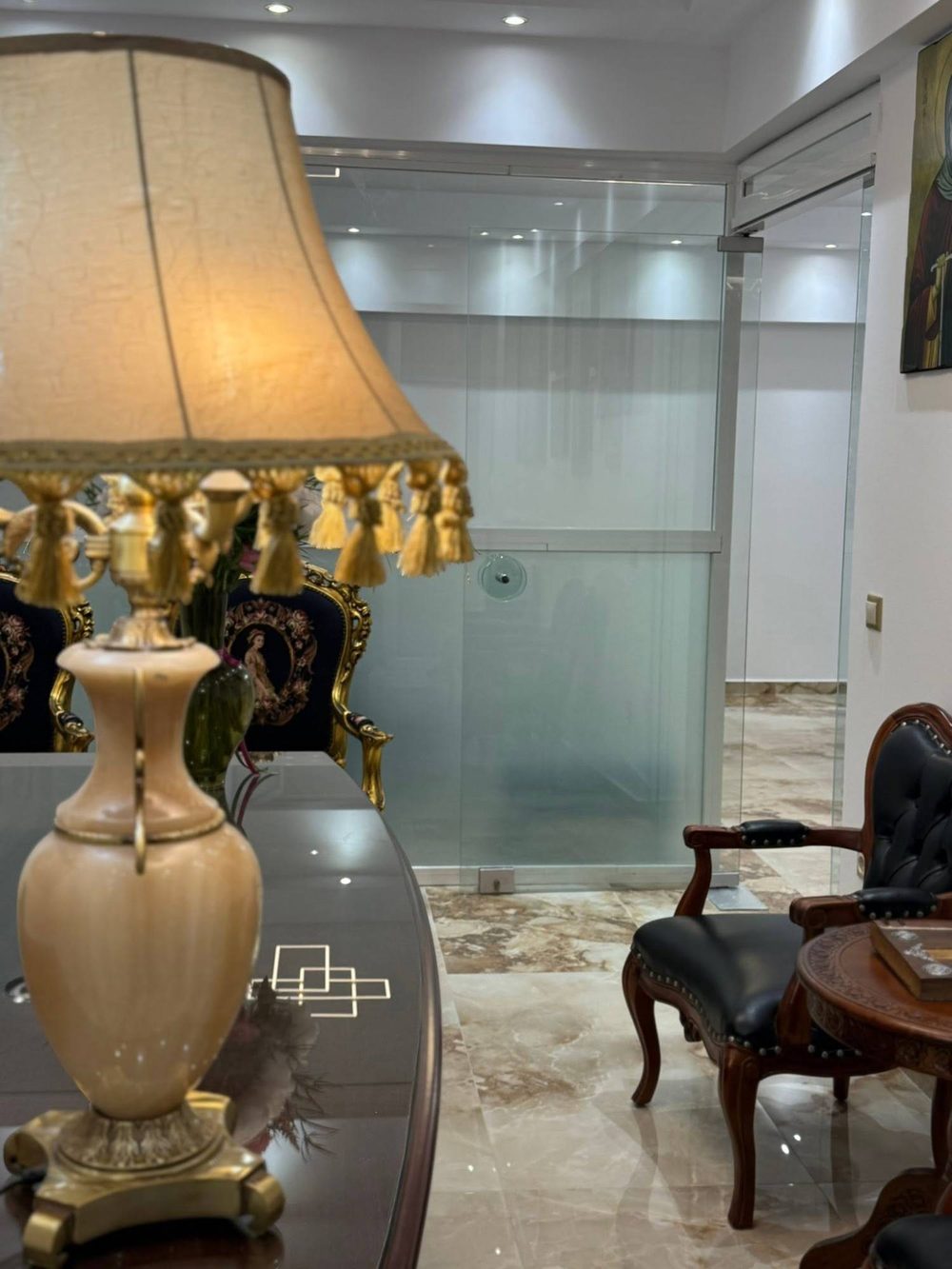 Τραπέζι συναντήσεων με επιτραπέζιο φωτιστικό, δερμάτινη πολυθρόνα και γυάλινη πόρτα.
