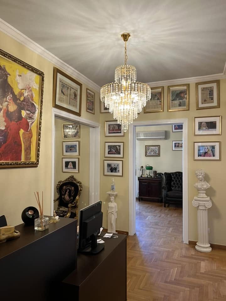 Κορνιζαρισμένα δημοσιεύματα και τηλεοπτικά στιγμιότυπα στον τοίχο ενός χώρου υποδοχής.